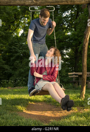 Mädchen junge Paar auf Schaukel, Hand in Hand, Natur. Stockfoto