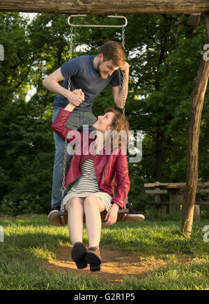 Mädchen junge Paar halten Hände schwingen, Natur. Stockfoto