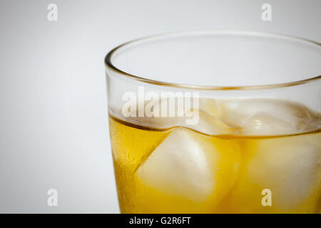 Glas Whiskey mit Eis in weißem Hintergrund. (Nahaufnahme) Stockfoto