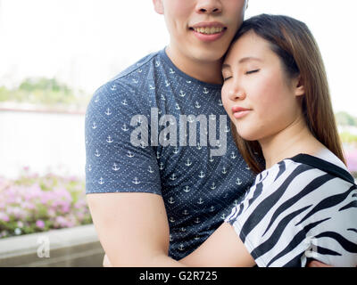 Asian paar umarmen einander in der Outdoor-park Stockfoto