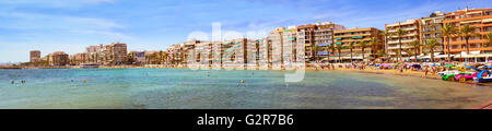 TORREVIEJA, Spanien - 13. September 2014: Sonnige Mittelmeer Strand, Touristen auf warmen Sand auf Liegestühlen unter Sonnenschirmen entspannen Stockfoto