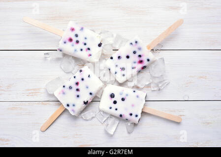 Hausgemachtes Eis gefrorenen Eis am Stiel aus Joghurt und Heidelbeere auf hölzernen Bckground, Ansicht von oben Stockfoto