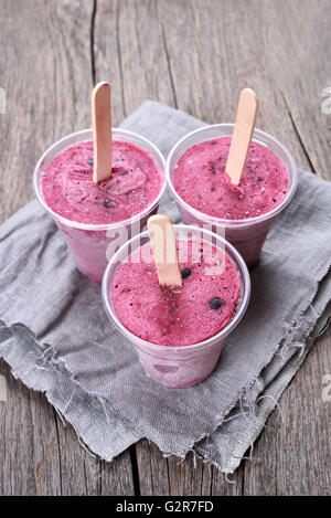 Schwarze Johannisbeere Blaubeer Eis am Stiel gemacht in Plastikbechern Stockfoto