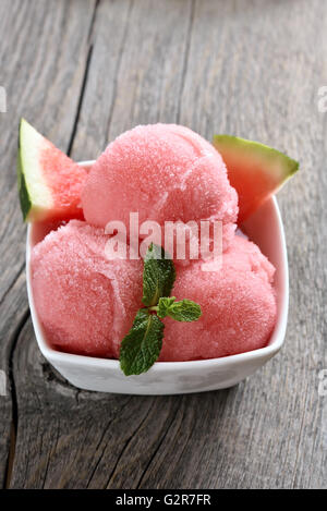 Wassermelonen-Eis-Sorbet in Schüssel auf hölzernen Hintergrund Stockfoto