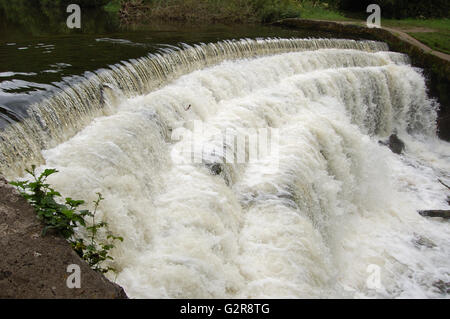 Wehr am Fluss Wye Monsal Dale in voller Kraft Stockfoto