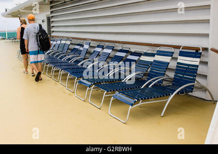 Liegestühle für Touristen an Bord eines Kreuzfahrtschiffes aufgereiht Stockfoto