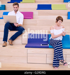 Frau SMS auf Handy und Mann mit modernen Notebook Surfen Stockfoto