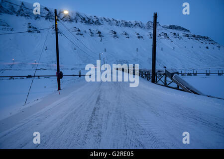 Schneebedeckte Straße im Winter und Polarnacht im Longyear Valley, Longyearbyen, Spitzbergen, Svalbard, Norwegen Stockfoto