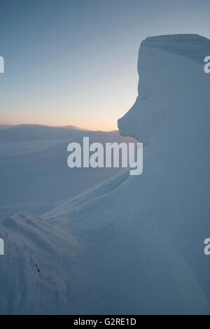 Winterliche Lichtverhältnisse und Wildnis in der arktischen Landschaft von Svalbard bei Trollsteinen. Schnee lässt Felsen wie ein Gesicht aussehen.Spitzbergen, Spitzbergen, Norwegen Stockfoto