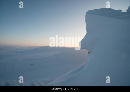 Winterliche Lichtverhältnisse und Wildnis in der arktischen Landschaft von Svalbard bei Trollsteinen. Schnee lässt Felsen wie ein Gesicht aussehen.Spitzbergen, Spitzbergen, Norwegen Stockfoto