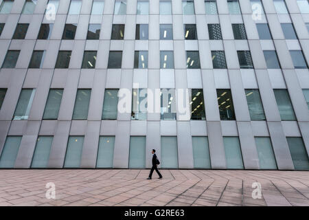 Eine japanische männlicher Büroangestellter oder Salaryman geht vor ein Bürogebäude in Shinjuku, Tokyo, Japan Stockfoto