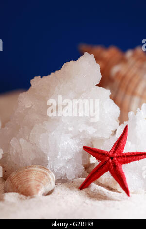 Stücke von echten Salz vom Toten Meer auf Sand in der Nähe von Seestern Stockfoto