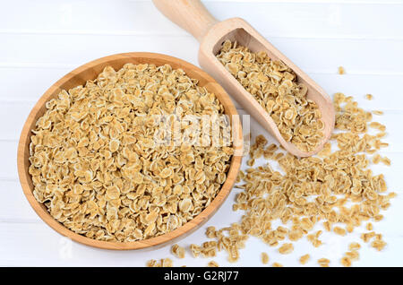 Schüssel mit Hafer und Schaufel auf Holztisch Stockfoto