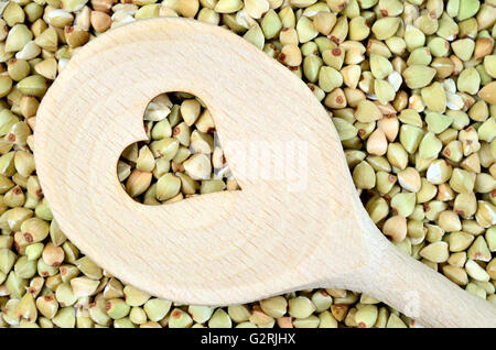 Kochlöffel mit Herzform in einem grünen Buchweizen-Hintergrund Stockfoto