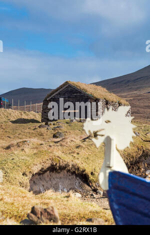 Gras überdachte Bootshaus mit Wikingerschiff Kopf, Leitisvatn Sørvágsvatn, Vagar, Färöer, Dänemark im April - Färöer Leitisvatn Sorvagsvatn Stockfoto