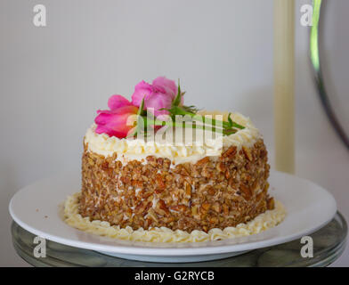 schön gemacht frisch Karottenkuchen mit echten rosa Rosen an der Spitze Stockfoto