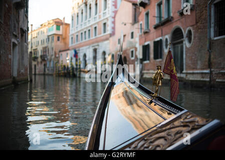 Eine Nahaufnahme von der Vorderseite des Gondel-Boot mit einem Miniatur-Mann und die Gebäude in der Front, Venedig, Italien. Stockfoto