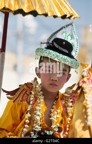 Ein Junge gekleidet für Shinbyu Novitiation Zeremonie durchgeführt auf Schultern unter eine vergoldete Dach, Botataung-Pagode, Yangon, Myanmar Stockfoto