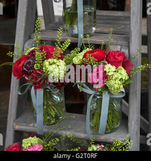 Bouquet von Hortensie, Nelken und Hortensien in einem Glas auf der Treppe Stockfoto