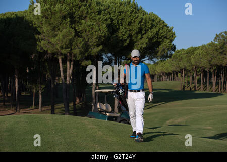 schöne orientalische Golfer Tragetasche und zu Fuß zum nächsten Loch am Golfplatz Stockfoto