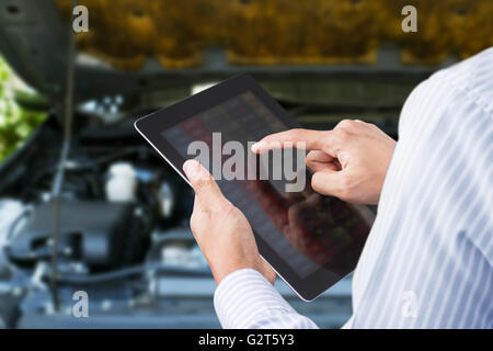 Nahaufnahme eines Mannes prüfen das Auto auf Touchscreen-Tablet in einer garage Stockfoto