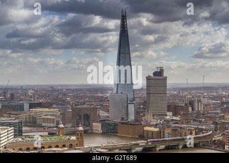 Der Shard mit Guy's Tower, ein Teil von Guy's Hospital, der daneben steht, mit Zügen über die Cannon Street Railway Bridge, Southwark, London, Großbritannien Stockfoto