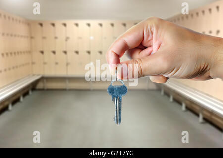 Männliche Hand, die einen Schlüssel in eine leere Umkleidekabine Stockfoto