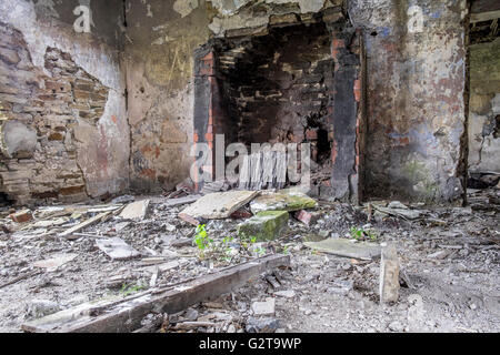 Ein verfallenes Haus mit Müll und Schutt auf dem Boden von der Grotte in und das Kamin fehlt Stockfoto