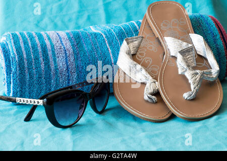 Strandtuch mit Sonnenbrille und Flip Flops Sandalen Stockfoto