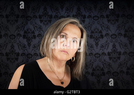 Nachdenklich mittlere gealterte Frau nachschlagen Stockfoto