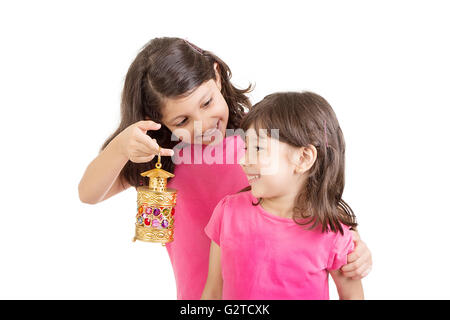 Happy Family im Ramadan - muslimische Schwestern feiern Ramadan - spielen mit Ramadan Laterne vor Ramadan Hintergrund Stockfoto