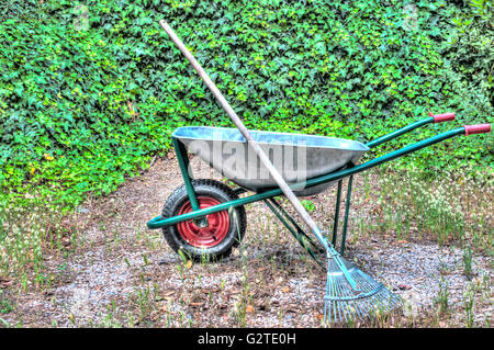 HDR der Schubkarre in einem Garten und einer Harke Stockfoto