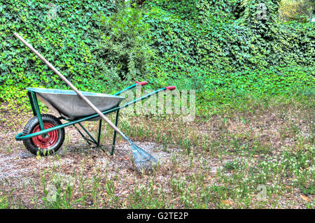 HDR der Schubkarre in einem Garten und einer Harke Stockfoto