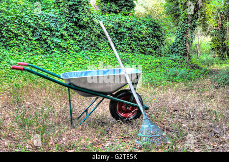 HDR der Schubkarre in einem Garten und einer Harke Stockfoto