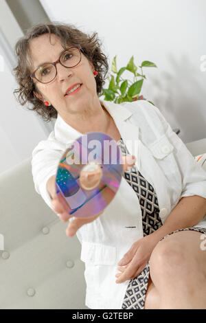 eine reife Frau mit einer CD-ROM Stockfoto