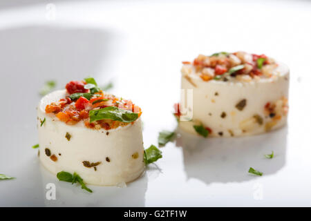 Köstlichen Häppchen mit Käse und verschiedenen Zutaten auf weißen Teller Stockfoto