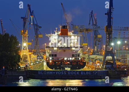 Containerschiff im Schwimmdock von Blohm und Voss, Hamburger Hafen bei Nacht, Hamburg, Deutschland Stockfoto