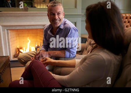 Älteres paar offene Feuer Champagner trinken sitzen Stockfoto
