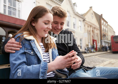 Teenager-Paar mit Handy im städtischen Umfeld Stockfoto