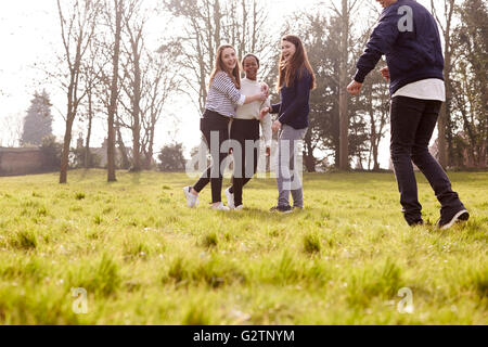 Gruppe von Jugendlichen spielen Fußball im Park zusammen Stockfoto