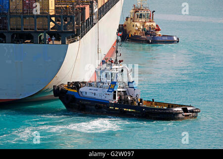 Schlepper drücken Frachter im Hafen Stockfoto