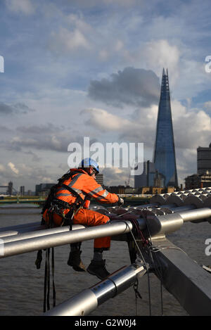 Ein Ingenieur führt wesentliche Wartung auf einer Londoner Brücke, gegenüber der majestätischen Shard. Stockfoto