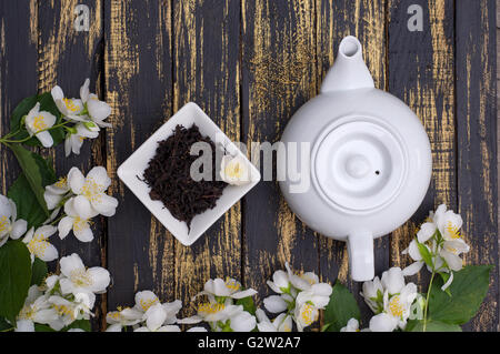 Schwarzer Tee mit Teekanne auf dem Tisch mit Jasminblüten getrocknet Stockfoto