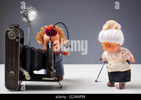 Marionetten der senior Fotograf seine alte Damen mit Vintage-Kamera im Studio zu fotografieren Stockfoto