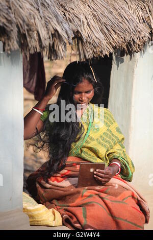 Dorf Frau, die ihre langen Haare einstellen vor Ihrer Lehmhütte in raiganj, Nord-bengalen Stockfoto