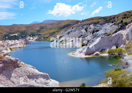 Blue Lake umgeben von weißen Quarz Felsen abgebaut für Gold im 19. Jahrhundert auf der Otago Rail Trail, St Bathans, Neuseeland Stockfoto