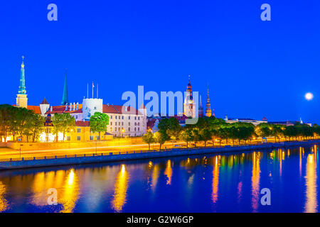 Die Altstadt von Riga mit Reflexion in den Fluss Daugava in der Nacht, Rigaer Schloss, Dom zu Riga, St. Peters Kirche. Riga, Lettland Stockfoto