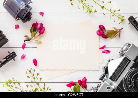 Leere Bilderrahmen für die Innenseite, Retro-Kamera Fotofilm rollt und Apple Blumen auf weißem Hintergrund. Flach legen, Top Aussicht. Stockfoto