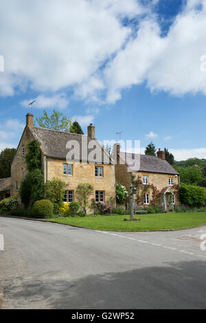 Cotswold Steinhütten mit roten Rosen. Stanton, Cotswolds, Gloucestershire, England Stockfoto