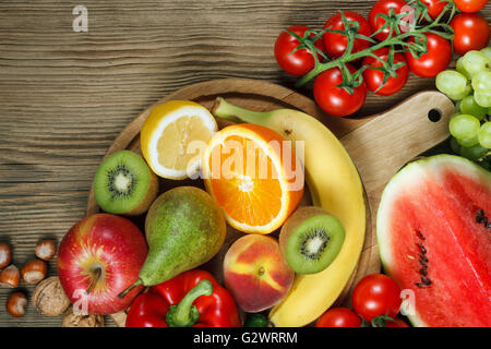 Vitamine in Obst und Gemüse. Natürliche Produkte, die reich an Vitaminen wie Orangen, Zitronen, Paprika, Kiwi, Tomaten, Bananen, Erbsen Stockfoto